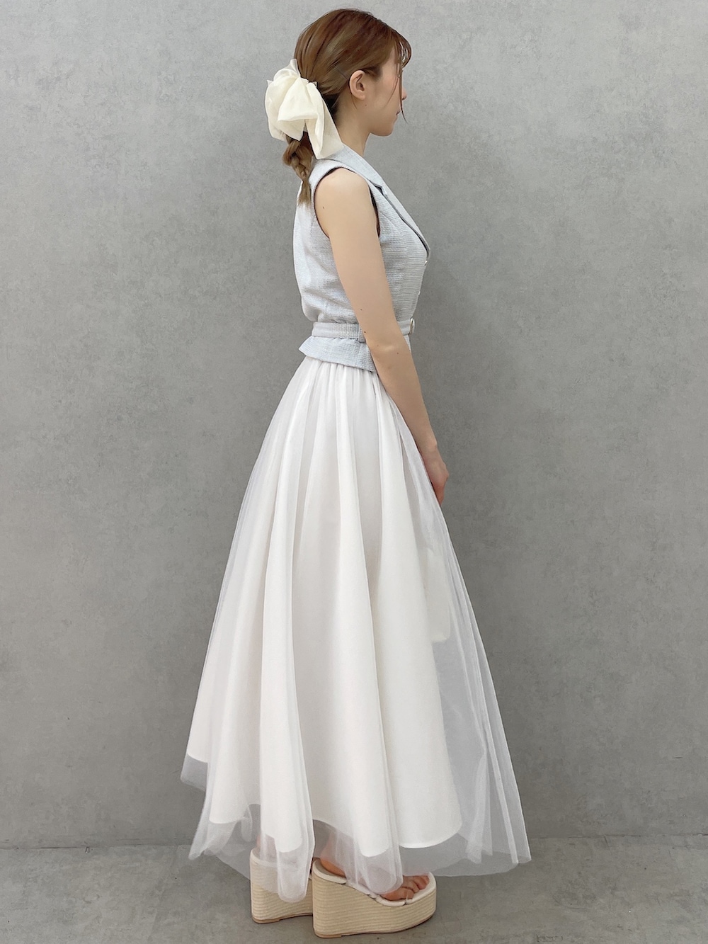 ブルー系のワンピース、ホワイト系のハンドバッグ、ホワイト系のサンダルを着用したレディースの春コーディネートの3枚目の写真