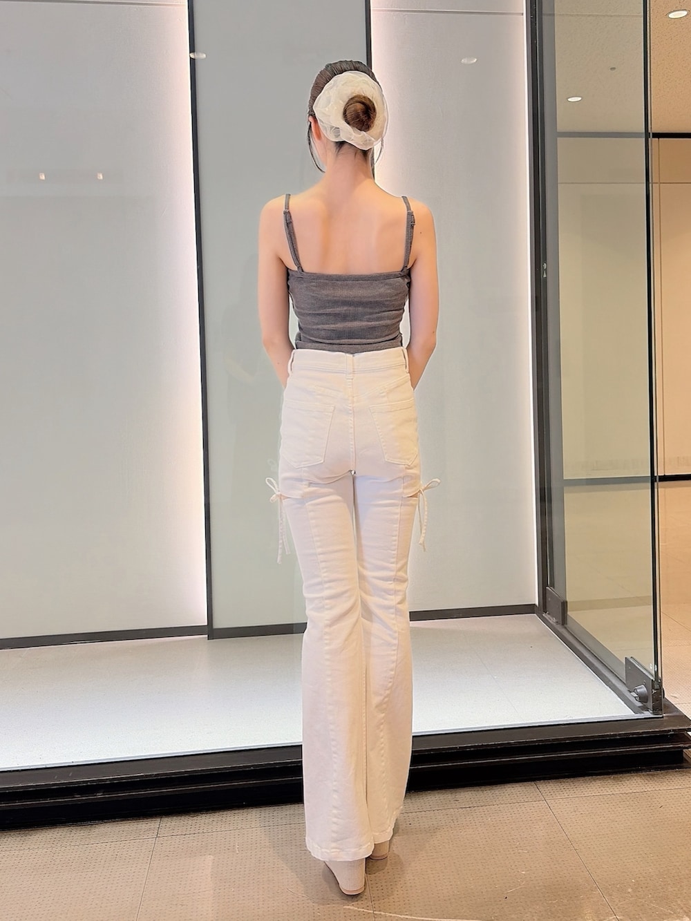 グレー系のTシャツ/カットソー、ホワイト系のデニムパンツ、ホワイト系のサンダルを着用したレディースの夏コーディネートの6枚目の写真