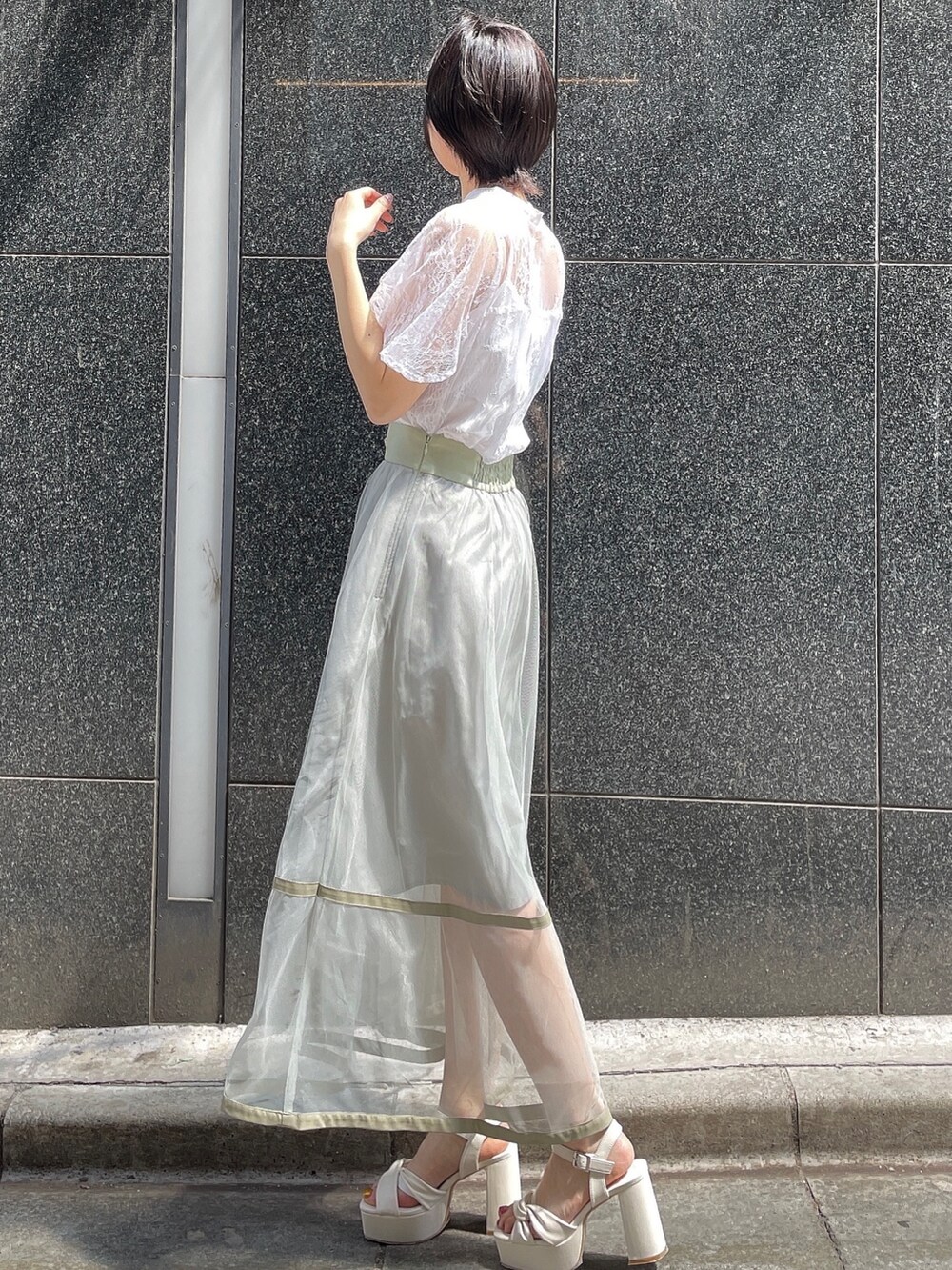 ホワイト系のシャツ/ブラウス、ホワイト系のサンダル、グリーン系のスカートを着用したレディースの春コーディネートの3枚目の写真