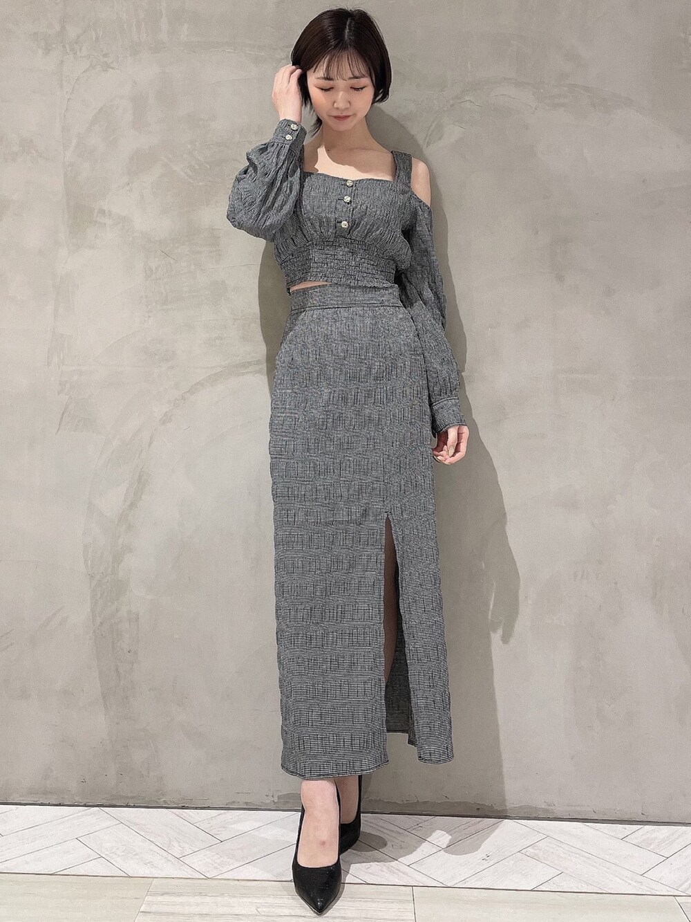 ブラック系のパンプス、ブラック系のスカート、ブラック系のシャツ/ブラウスを着用したレディースの冬コーディネートの2枚目の写真