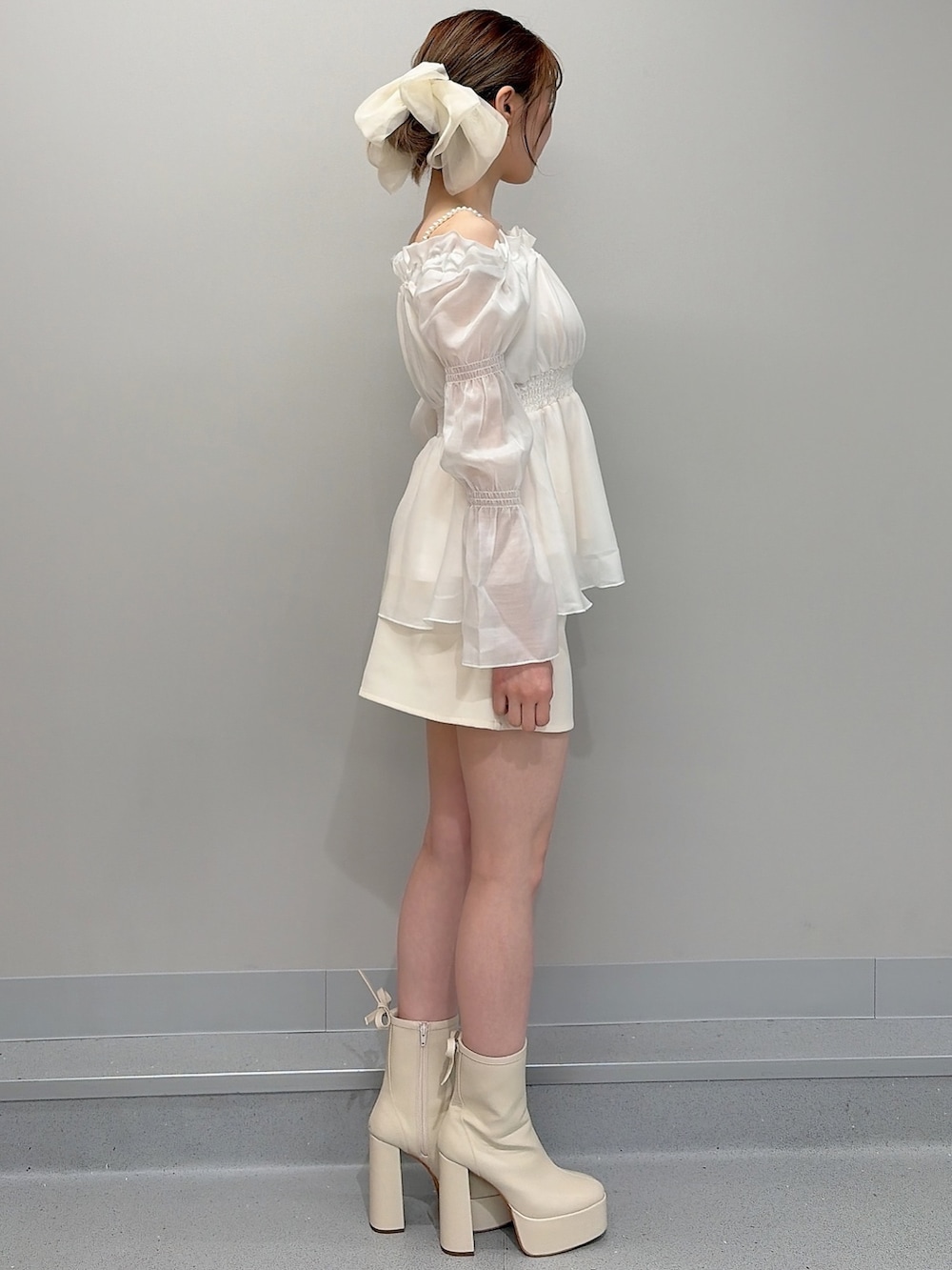 ホワイト系のブーツ、ホワイト系のシャツ/ブラウス、ホワイト系のスカートを着用したレディースの冬コーディネートの3枚目の写真