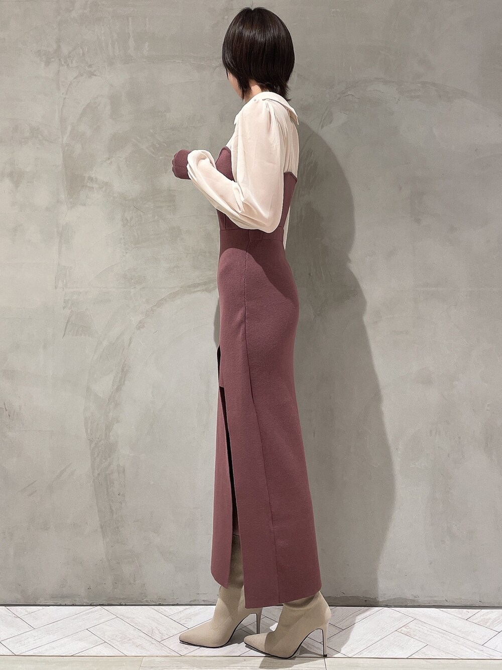 ベージュ系のトレンチコート、ブラウン系のワンピース、ホワイト系のブーツを着用したレディースの冬コーディネートの6枚目の写真