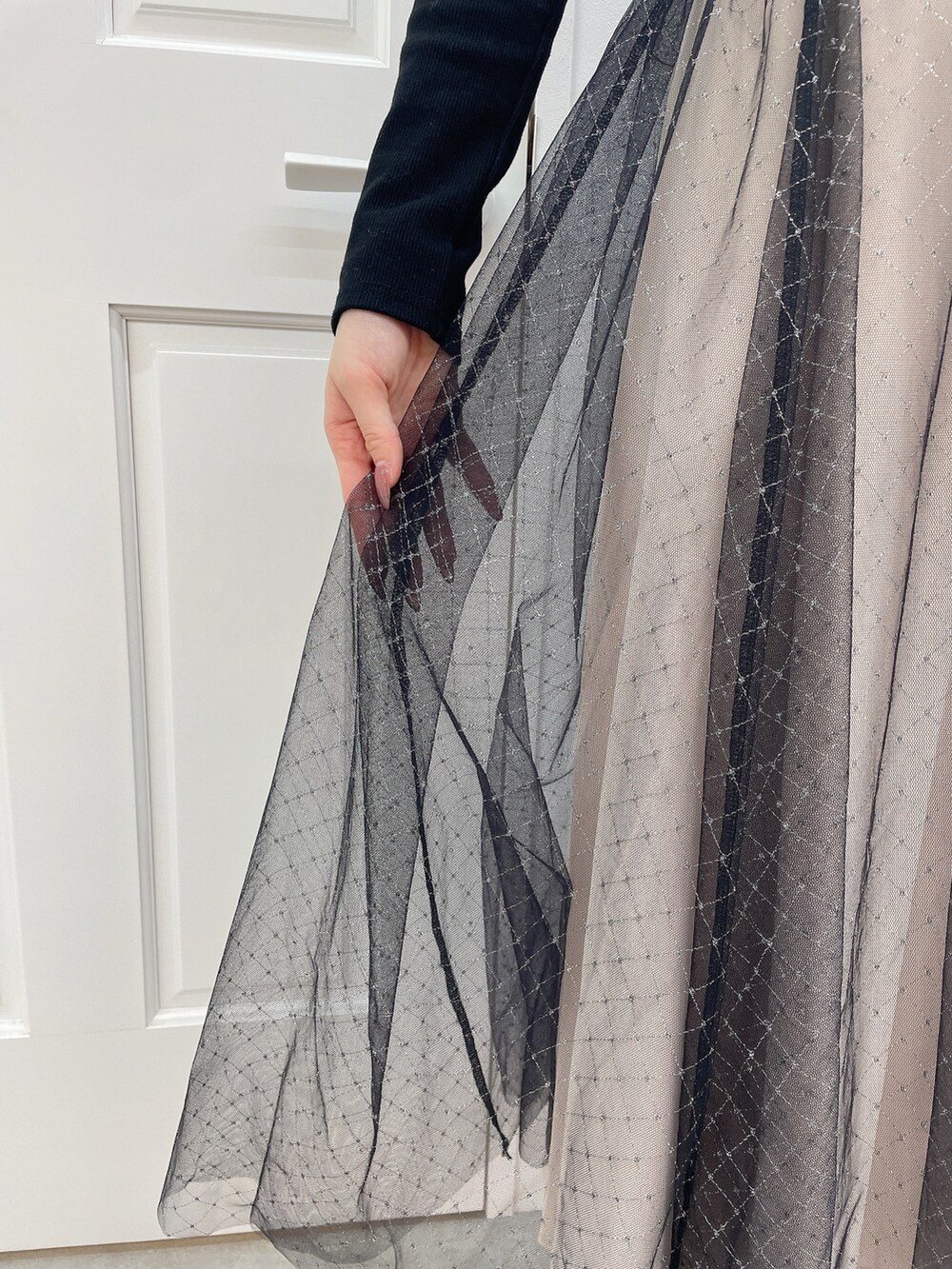 ブラック系のワンピース、ブラック系のハンドバッグ、ブラック系のパンプスを着用したレディースの冬コーディネートの8枚目の写真