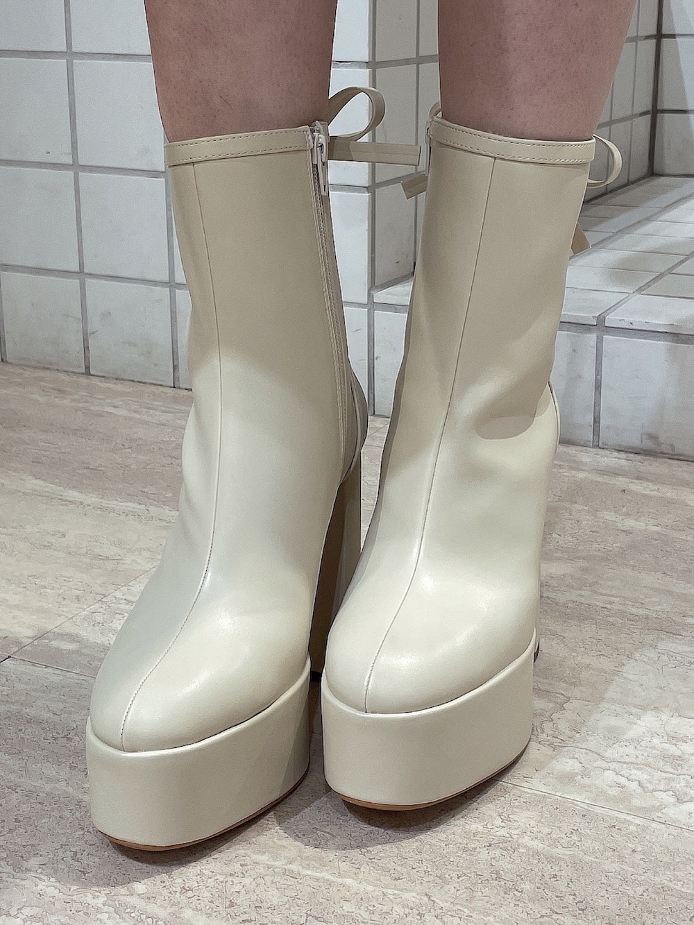 レッド系のニット/セーター、ホワイト系のスカート、ホワイト系のショルダーバッグを着用したレディースの冬コーディネートの10枚目の写真