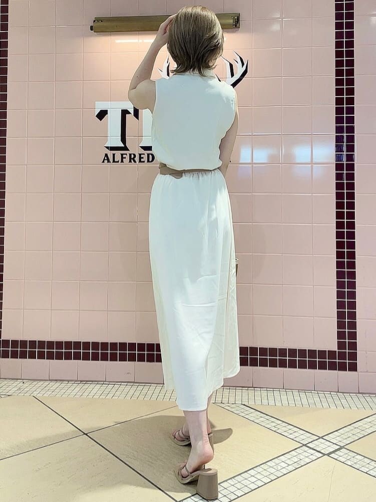 ピンク系のサンダル、ベージュ系のハンドバッグ、ホワイト系のシャツワンピースを着用したレディースの春コーディネートの3枚目の写真