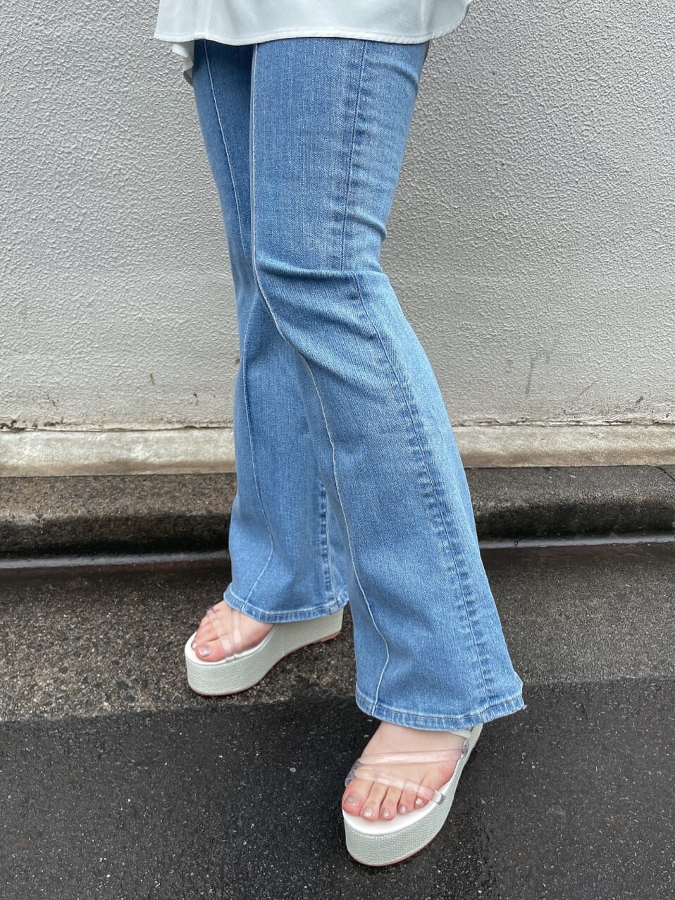 ホワイト系のサンダル、ベージュ系のハンドバッグ、ブルー系のデニムパンツを着用したレディースの夏コーディネートの8枚目の写真