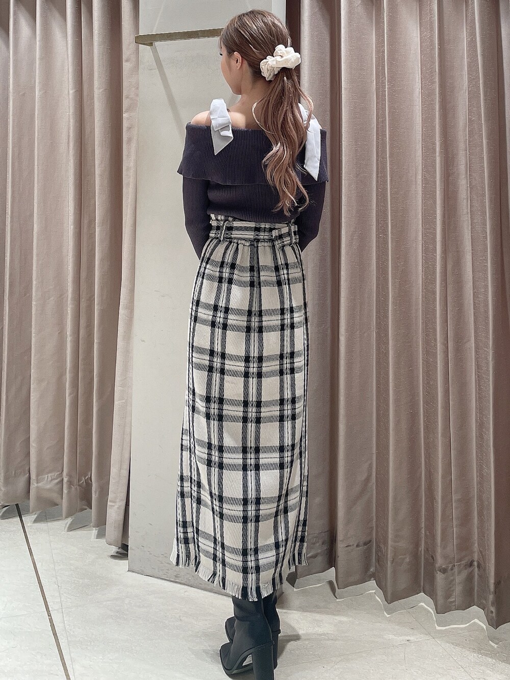 ブラック系のダウンジャケット/コート、グレー系のニット/セーター、ホワイト系のスカートを着用したレディースの秋コーディネートの8枚目の写真