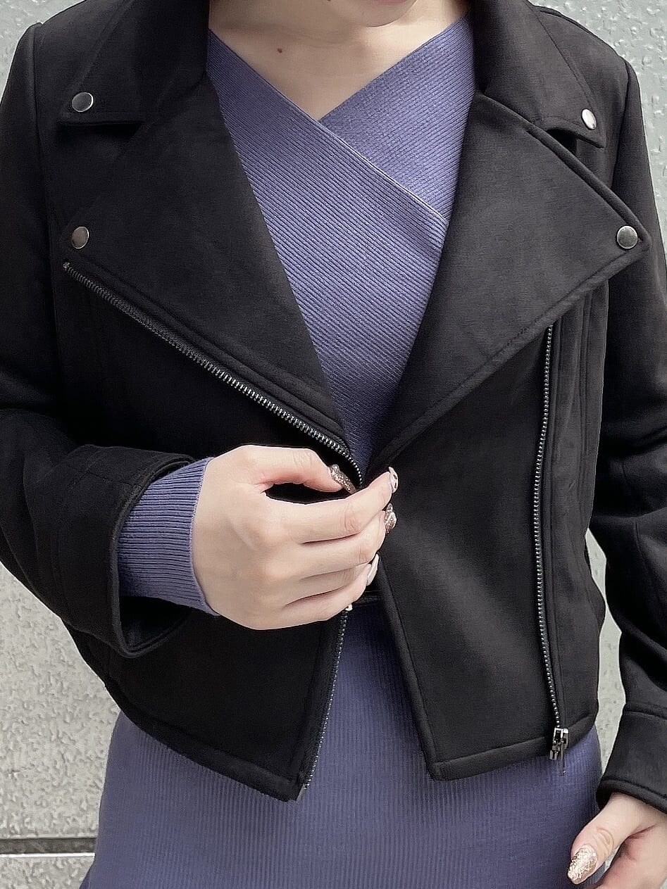 ブラック系のライダースジャケット、ブラック系のハンドバッグ、ブルー系のワンピースを着用したレディースの秋コーディネートの7枚目の写真