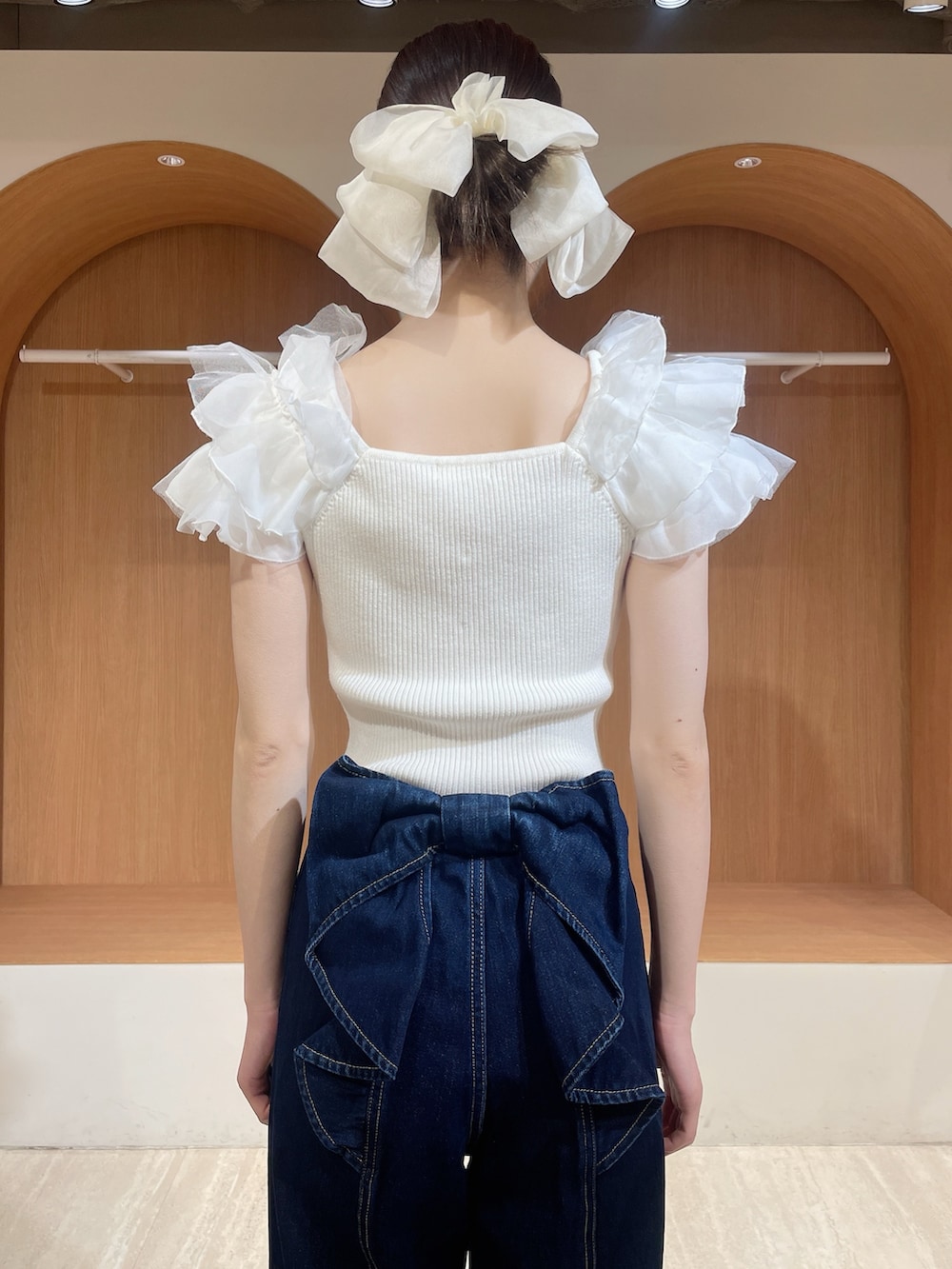 ホワイト系のニット/セーター、ブルー系のデニムパンツ、ホワイト系のサンダルを着用したレディースの春コーディネートの6枚目の写真