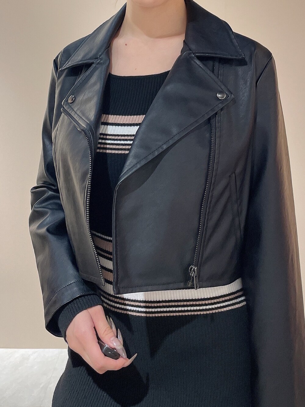 ブラック系のライダースジャケット、その他のワンピース、ブラック系のハンドバッグを着用したレディースの秋コーディネートの8枚目の写真