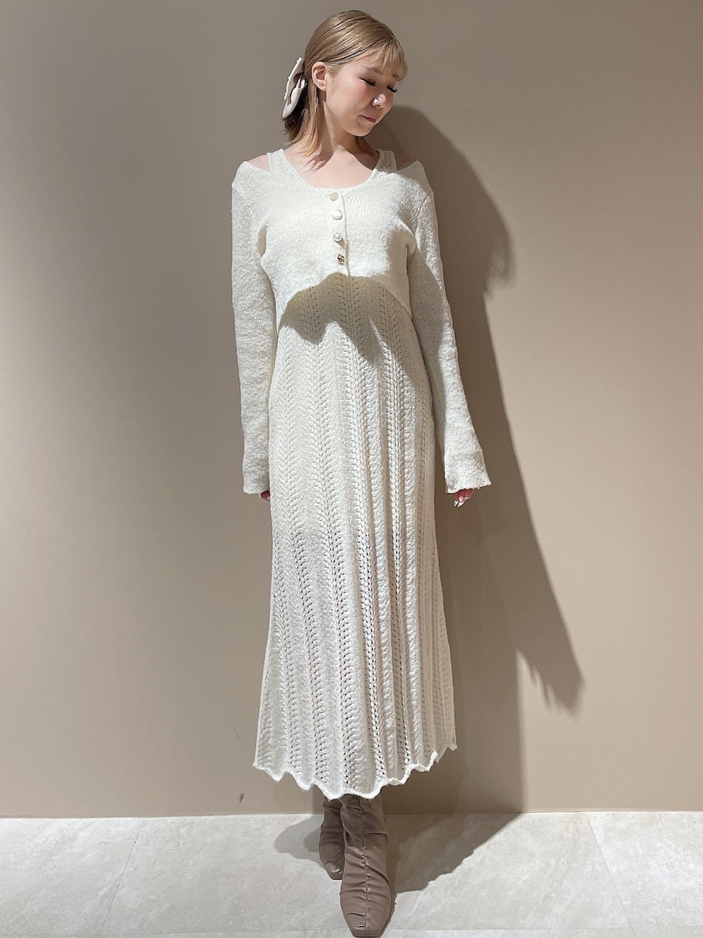 ベージュ系のブーツ、ベージュ系のダウンジャケット/コート、ホワイト系のワンピースを着用したレディースの秋コーディネートの7枚目の写真