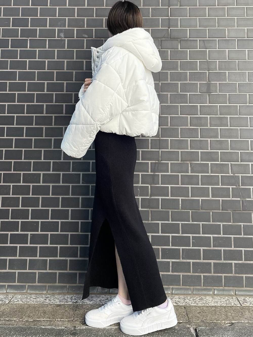 ブラック系のワンピース、ホワイト系のブルゾン、ホワイト系のスニーカーを着用したレディースの冬コーディネートの3枚目の写真