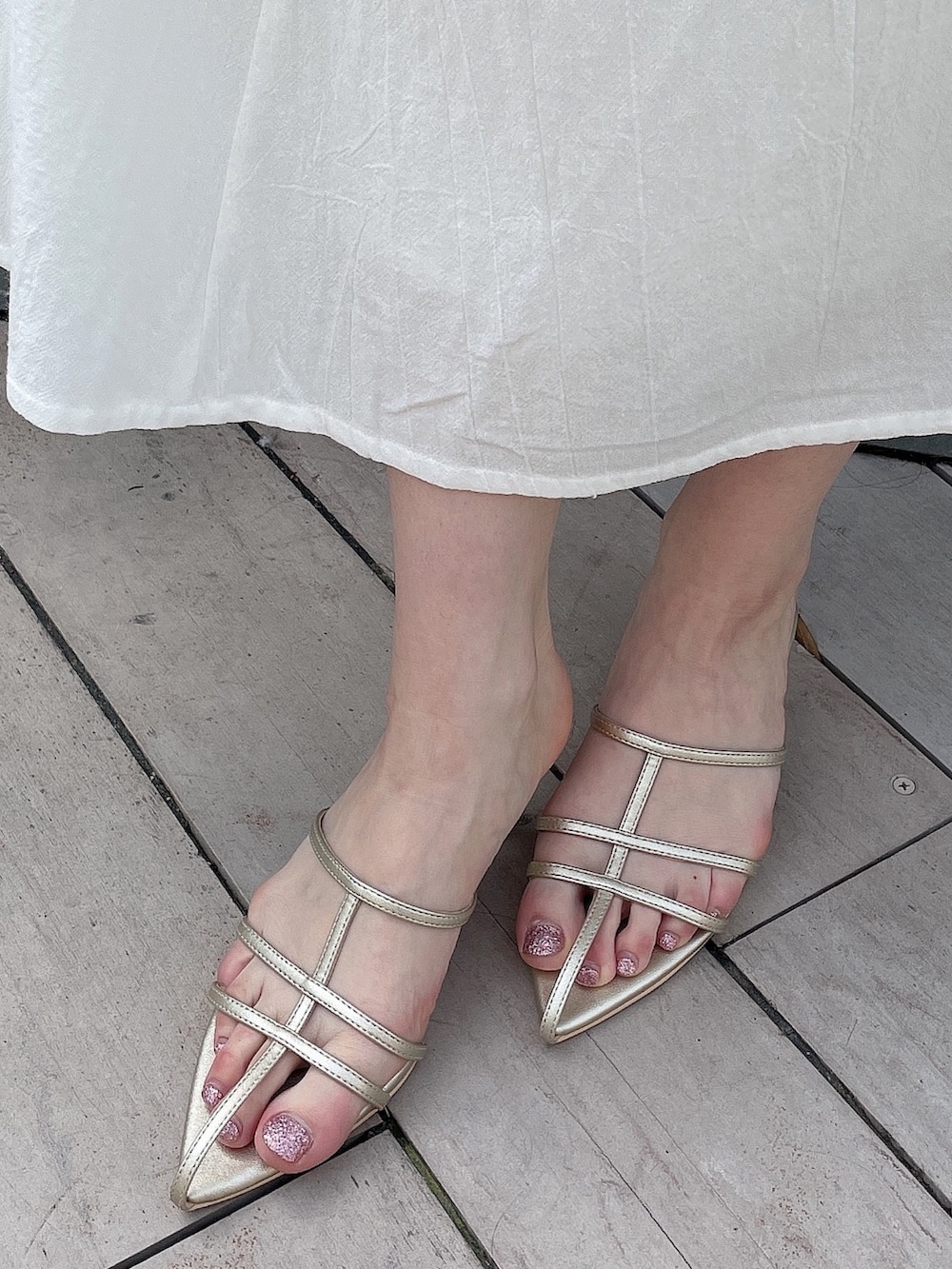 ホワイト系のワンピース、ブルー系のデニムジャケット、ゴールド系のサンダルを着用したレディースの春コーディネートの9枚目の写真