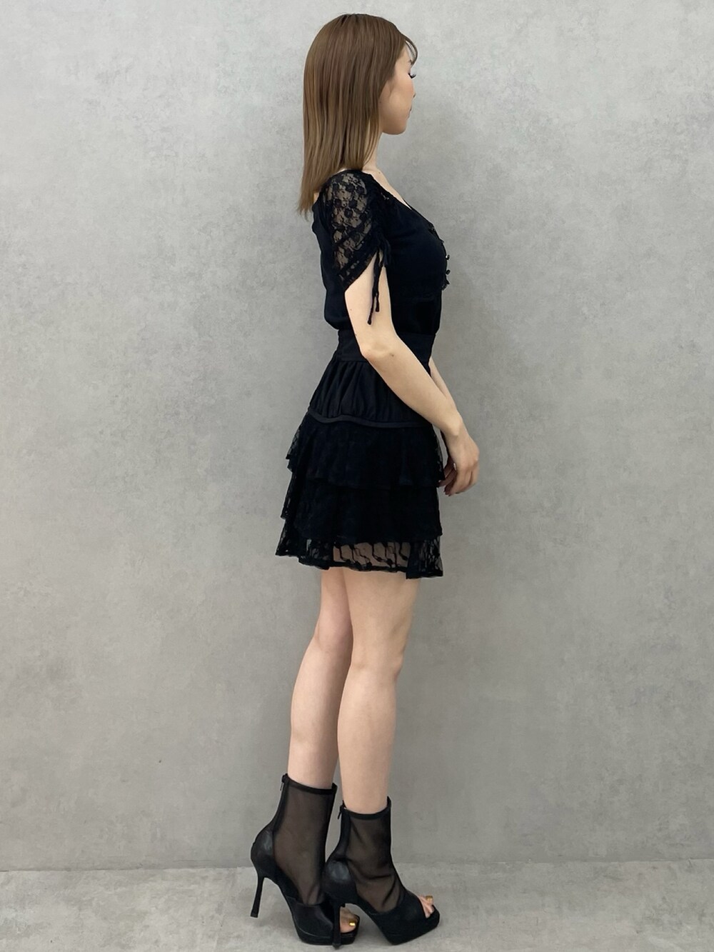 ブラック系のTシャツ/カットソー、ブラック系のスカート、ブラック系のブーツを着用したレディースの春コーディネートの2枚目の写真