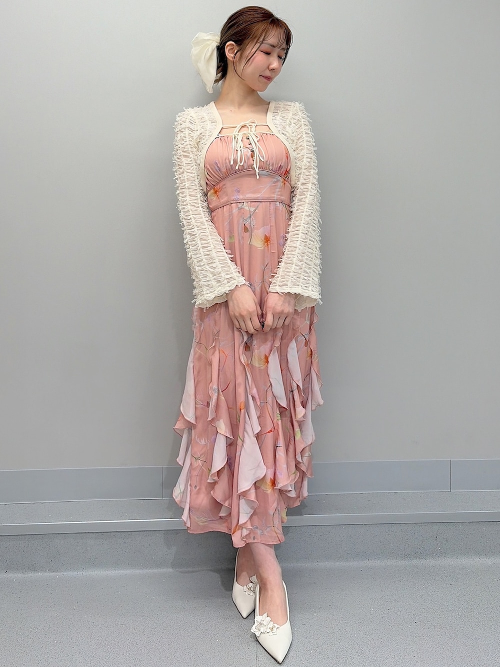 ホワイト系のパンプス、オレンジ系のワンピース、ホワイト系のバレッタ/ヘアクリップを着用したレディースの冬コーディネートの2枚目の写真