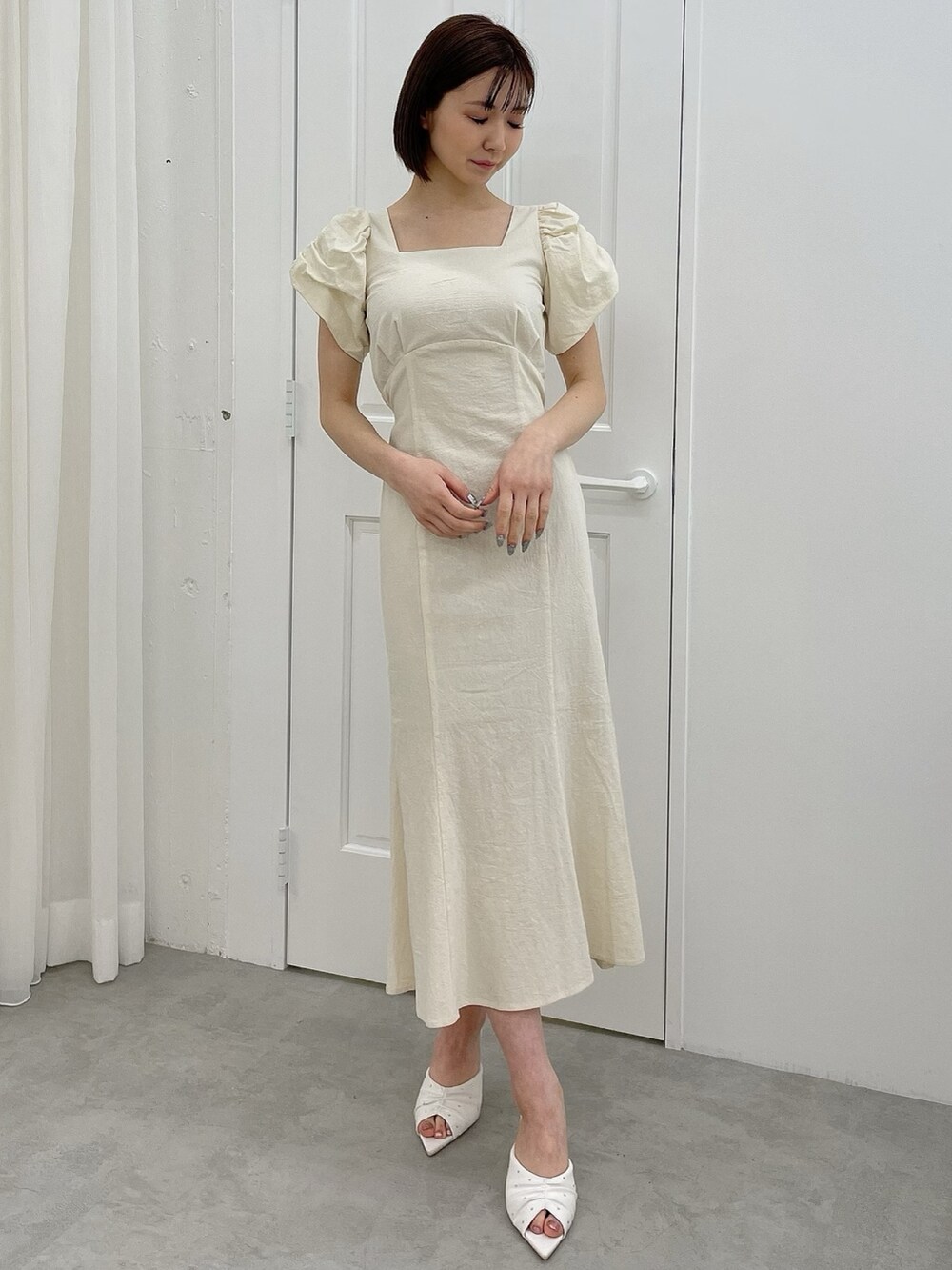 ホワイト系のワンピース、ホワイト系のサンダルを着用したレディースの春コーディネートの2枚目の写真