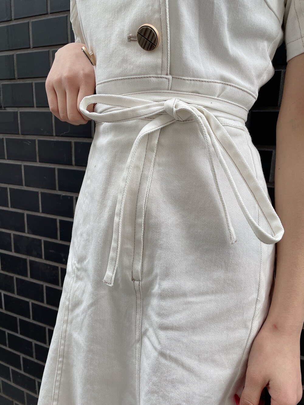 ホワイト系のワンピース、ブラック系のハンドバッグ、ホワイト系のパンプスを着用したレディースの春コーディネートの5枚目の写真