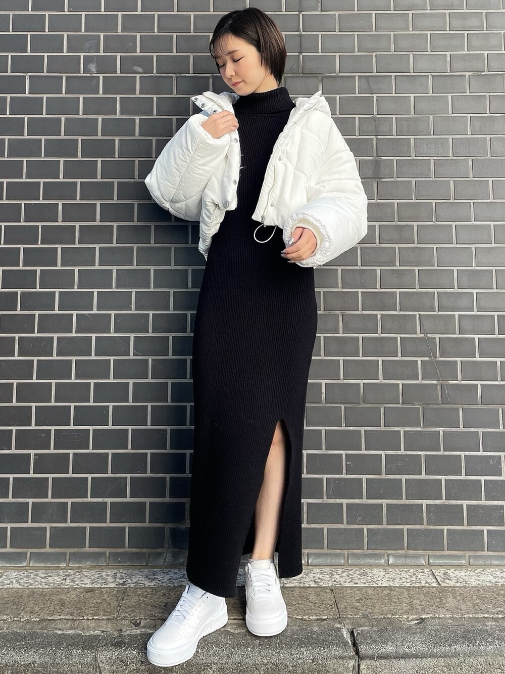 ブラック系のワンピース、ホワイト系のブルゾン、ホワイト系のスニーカーを着用したレディースの冬コーディネートの2枚目の写真