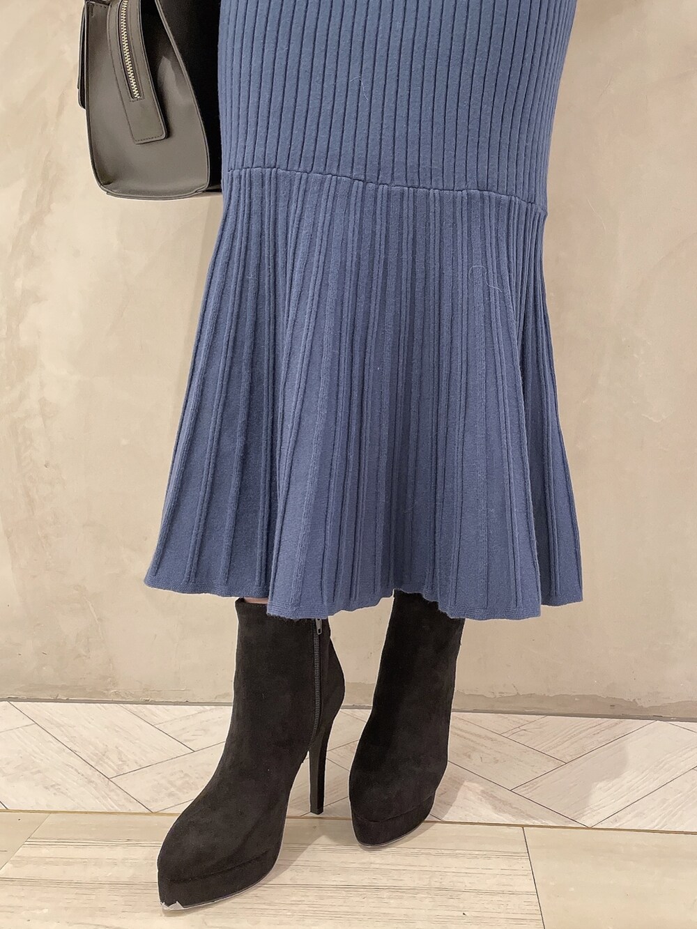 ブルー系のワンピース、ブラック系のブーツ、ブラック系のハンドバッグを着用したレディースの秋コーディネートの7枚目の写真