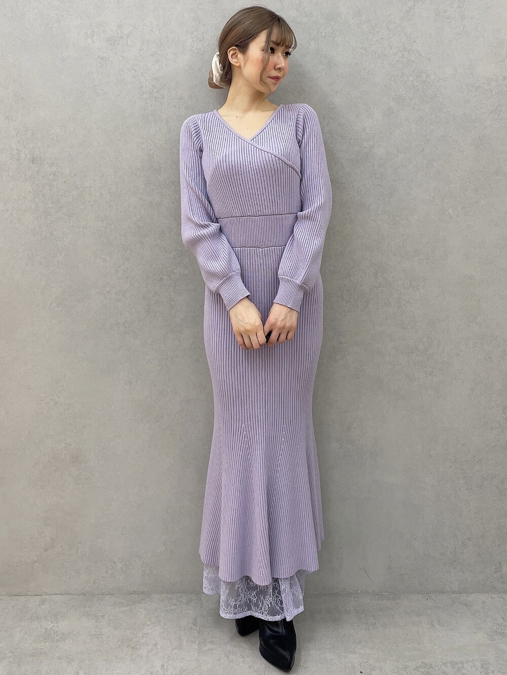 ブラック系のダウンジャケット/コート、パープル系のワンピース、ブラック系のハンドバッグを着用したレディースの秋コーディネートの5枚目の写真