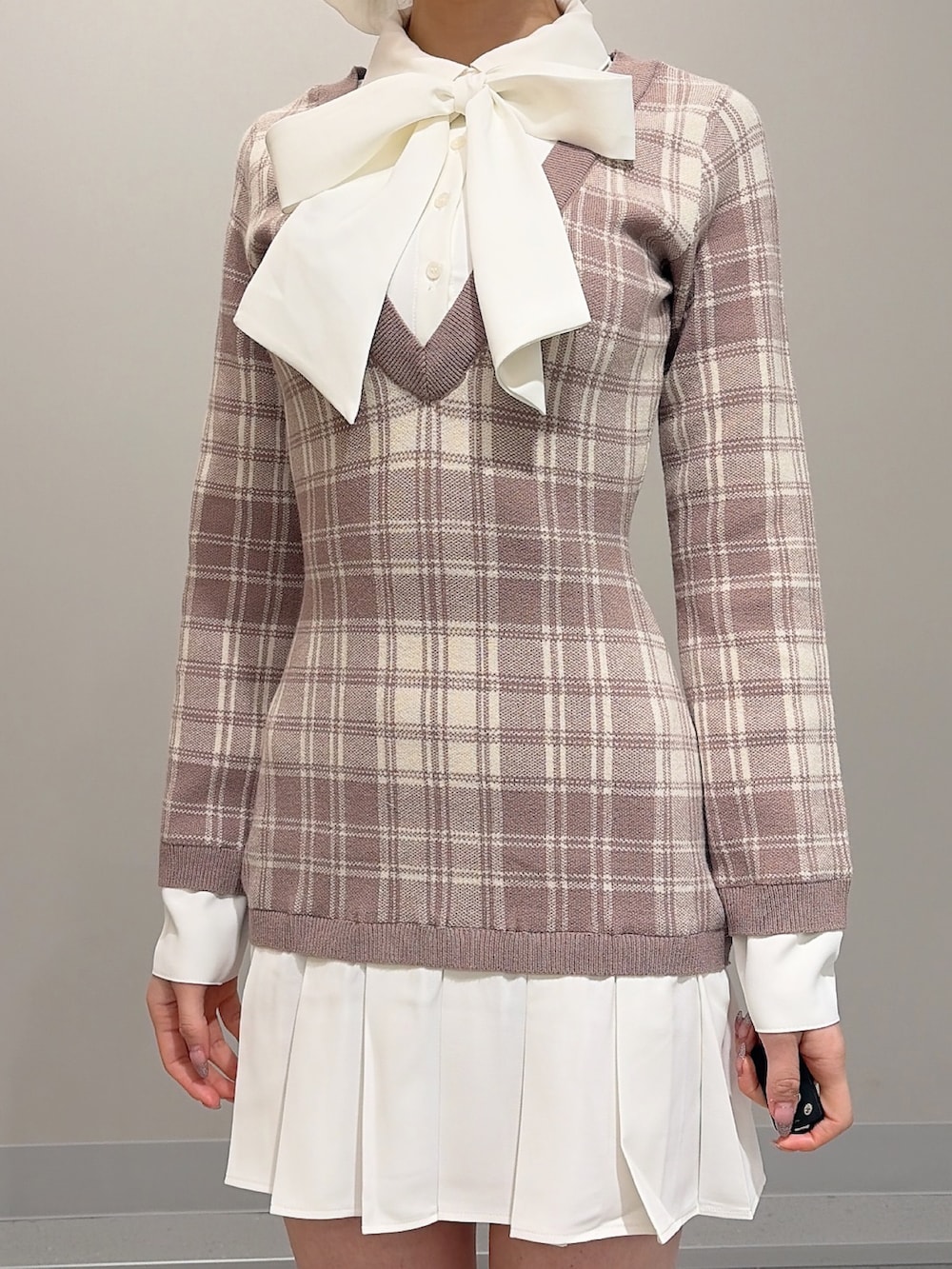 ベージュ系のワンピース、ホワイト系のブーツ、ホワイト系のバレッタ/ヘアクリップを着用したレディースの冬コーディネートの5枚目の写真