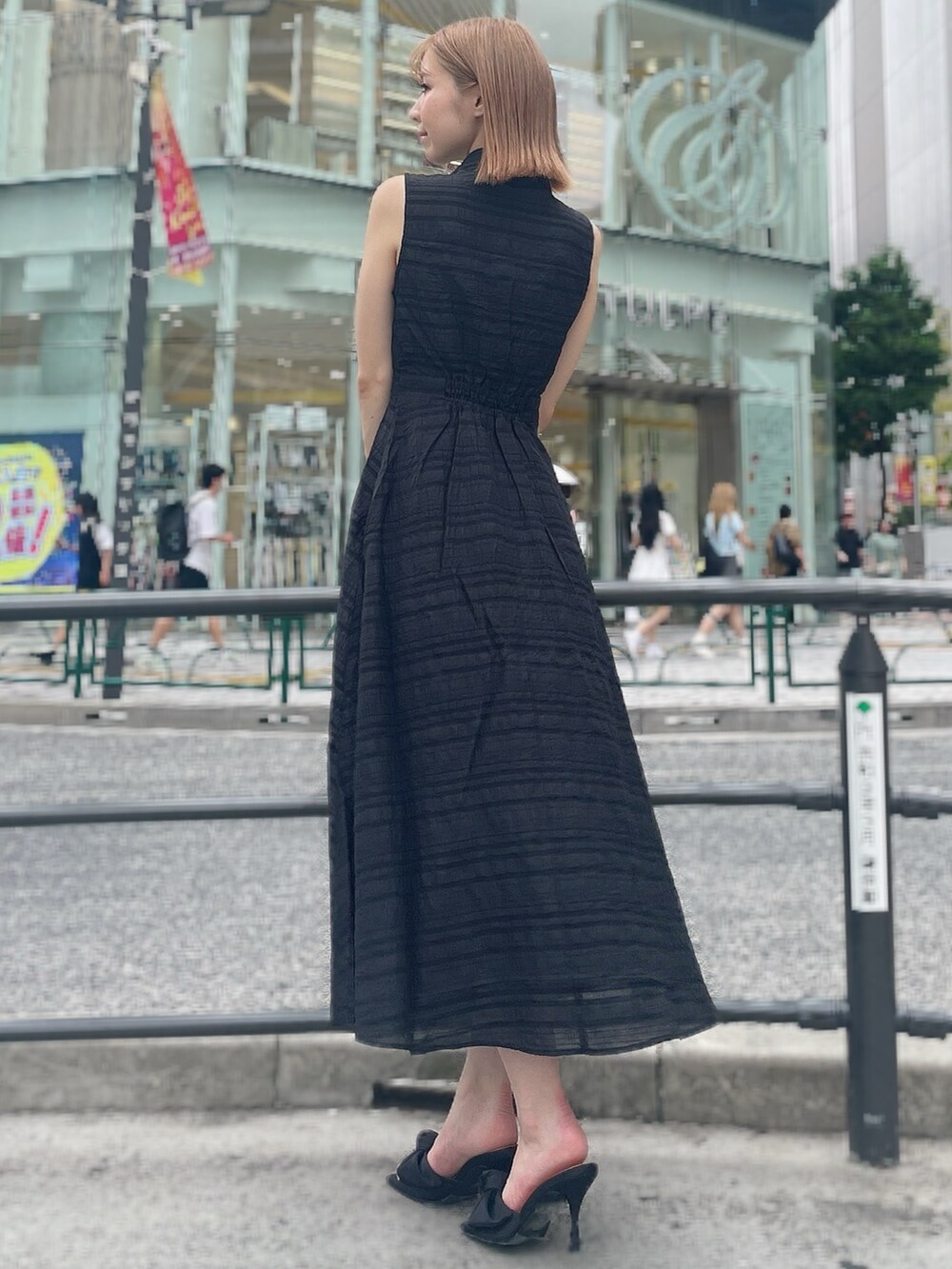 ブラック系のワンピース、ブラック系のサンダルを着用したレディースの夏コーディネートの4枚目の写真