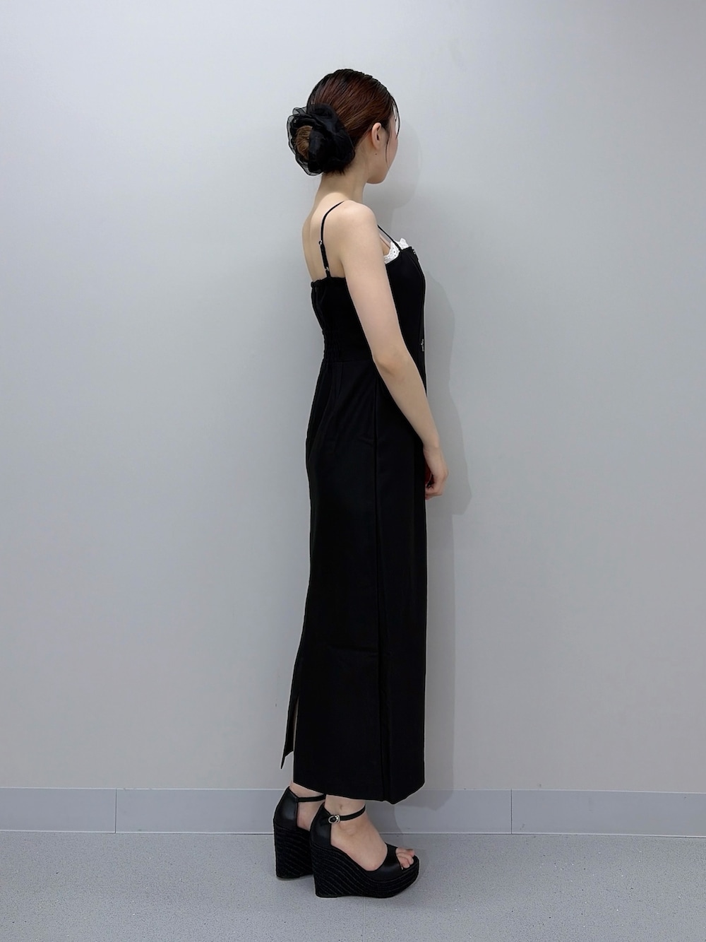 ブラック系のワンピース、ブラック系のサンダル、ブラック系のシュシュを着用したレディースの夏コーディネートの2枚目の写真
