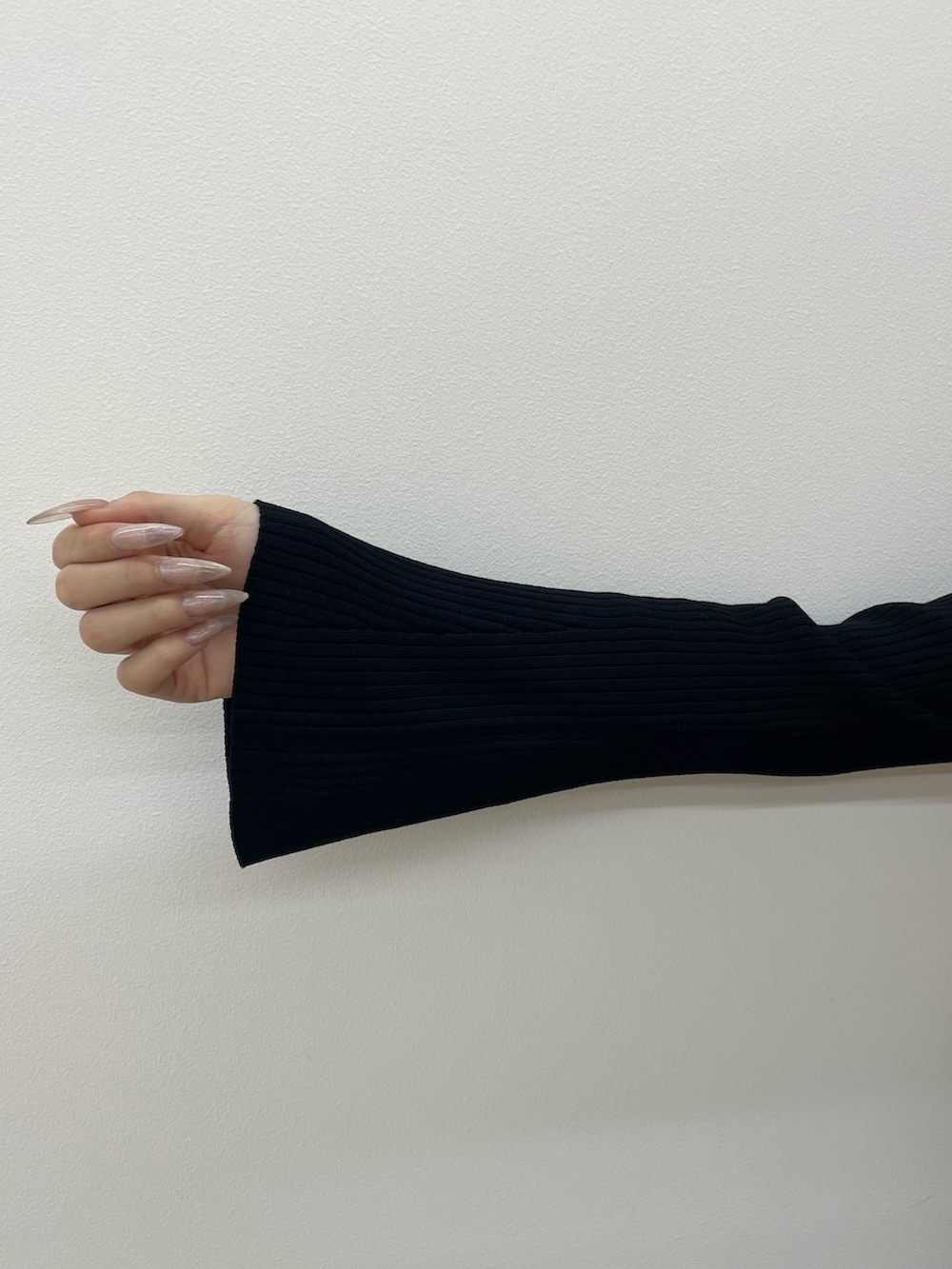 ブラック系のニット/セーター、ブラック系のスカート、ブラック系のブーツを着用したレディースの秋コーディネートの8枚目の写真