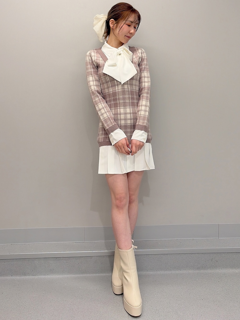 ベージュ系のワンピース、ホワイト系のブーツ、ホワイト系のバレッタ/ヘアクリップを着用したレディースの冬コーディネートの2枚目の写真