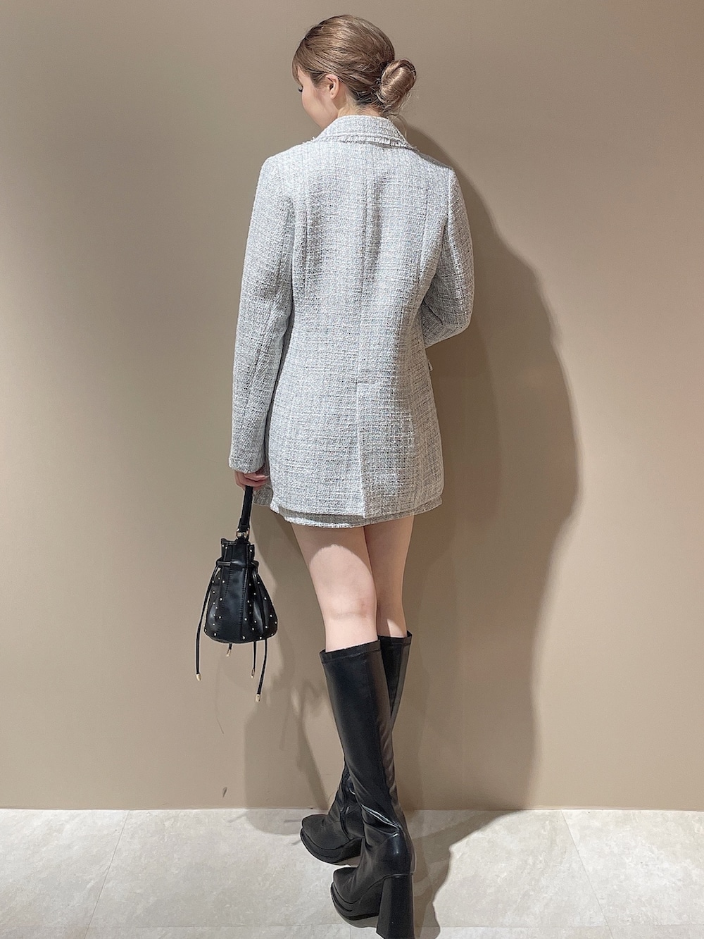 グレー系のテーラードジャケット、グレー系のスカート、ホワイト系のニット/セーターを着用したレディースの秋コーディネートの4枚目の写真