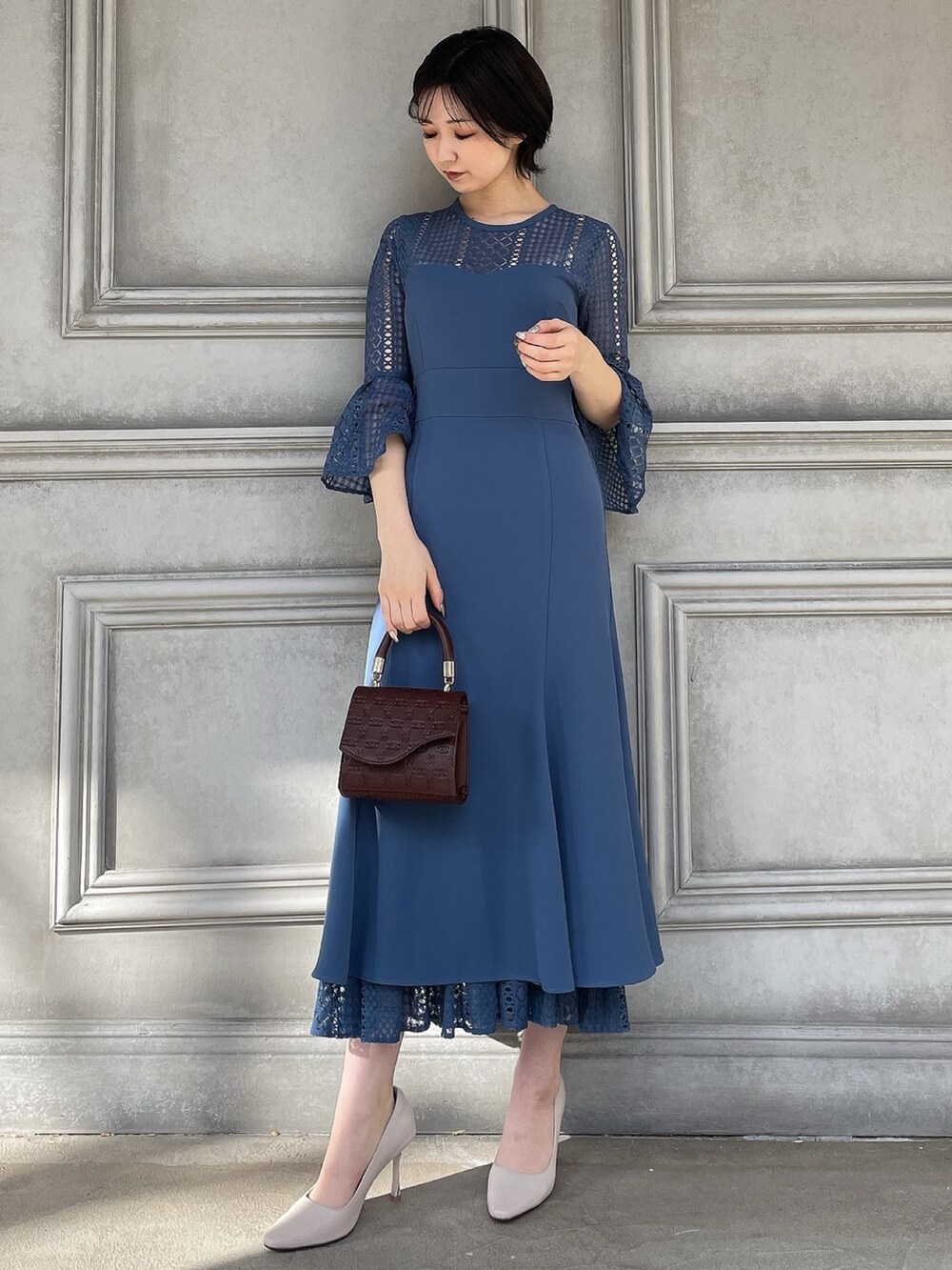 ホワイト系のテーラードジャケット、ブラウン系のハンドバッグ、ホワイト系のパンプスを着用したレディースの春コーディネートの4枚目の写真