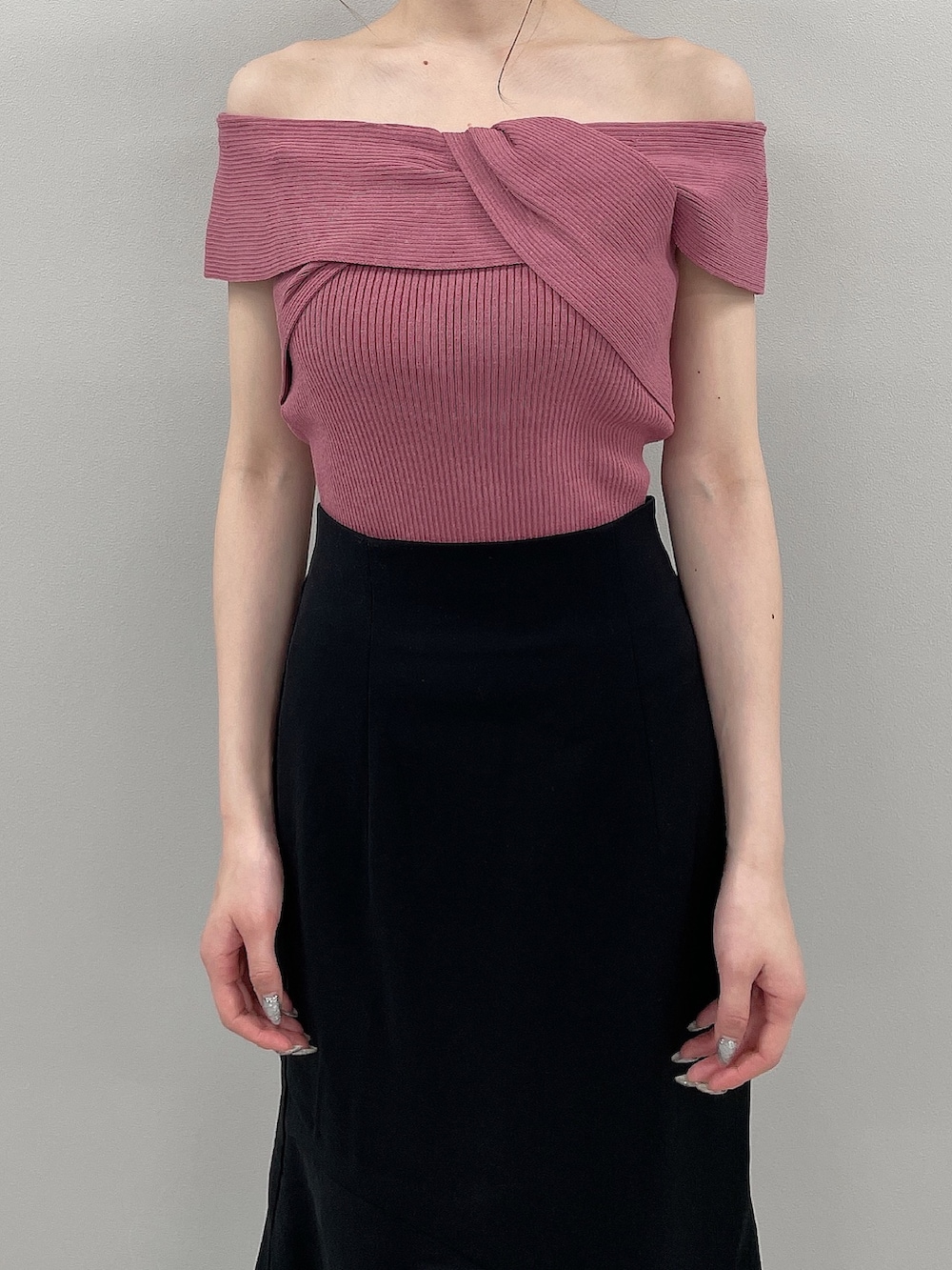 ピンク系のニット/セーター、ブラック系のスカート、ブラック系のサンダルを着用したレディースの春コーディネートの4枚目の写真