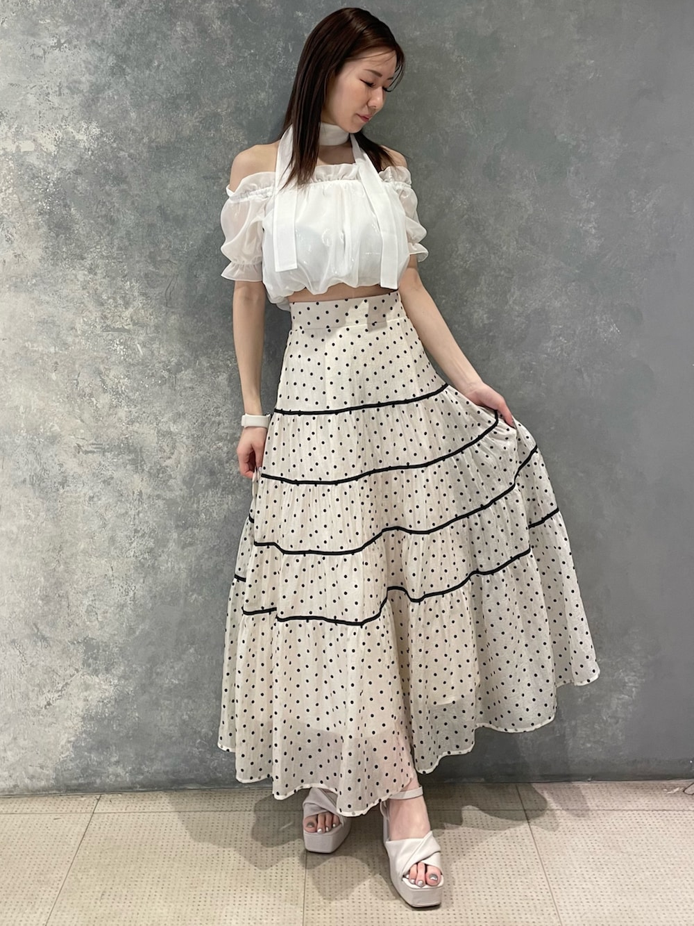 ホワイト系のシャツ/ブラウス、ホワイト系のスカート、ベージュ系のサンダルを着用したレディースの春コーディネートの2枚目の写真