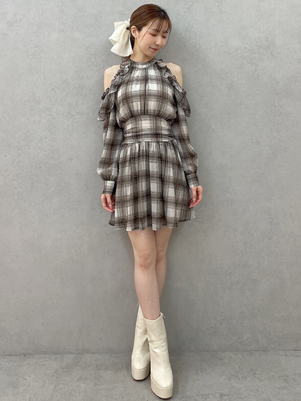 ブラウン系のワンピース、ホワイト系のブーツ、ホワイト系のバレッタ/ヘアクリップを着用したレディースの春コーディネートの2枚目の写真