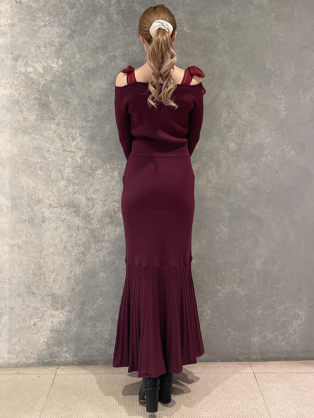 レッド系のワンピース、ブラック系のブーツを着用したレディースの秋コーディネートの4枚目の写真