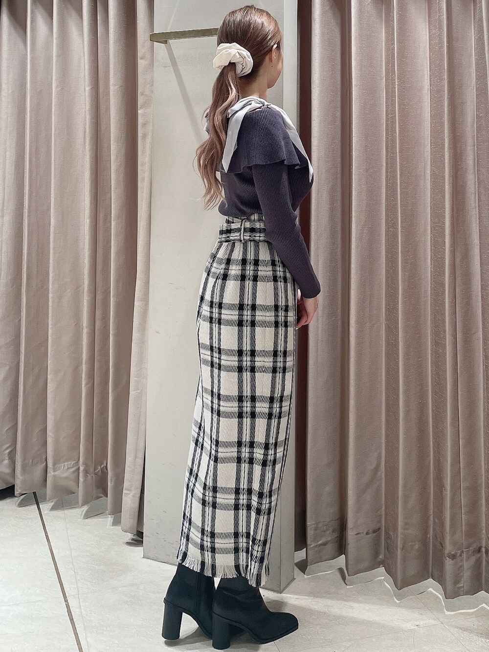 ブラック系のダウンジャケット/コート、グレー系のニット/セーター、ホワイト系のスカートを着用したレディースの秋コーディネートの7枚目の写真