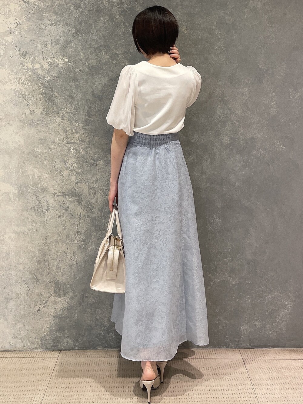 ホワイト系のサンダル、ブルー系のスカート、ホワイト系のTシャツ/カットソーを着用したレディースの春コーディネートの4枚目の写真