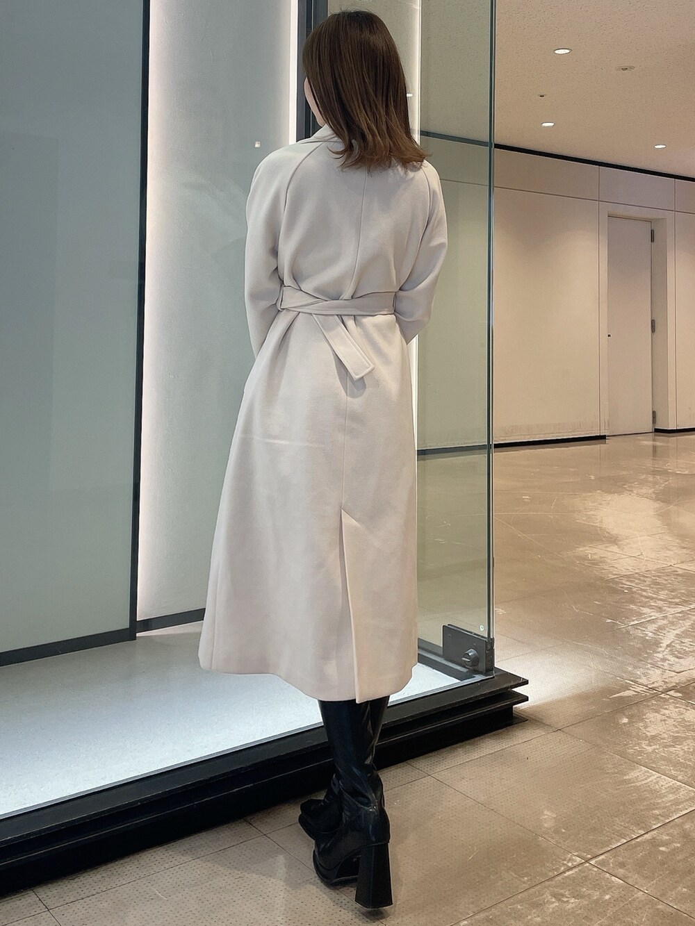 ホワイト系のその他アウター、ブラック系のブーツを着用したレディースの冬コーディネートの3枚目の写真