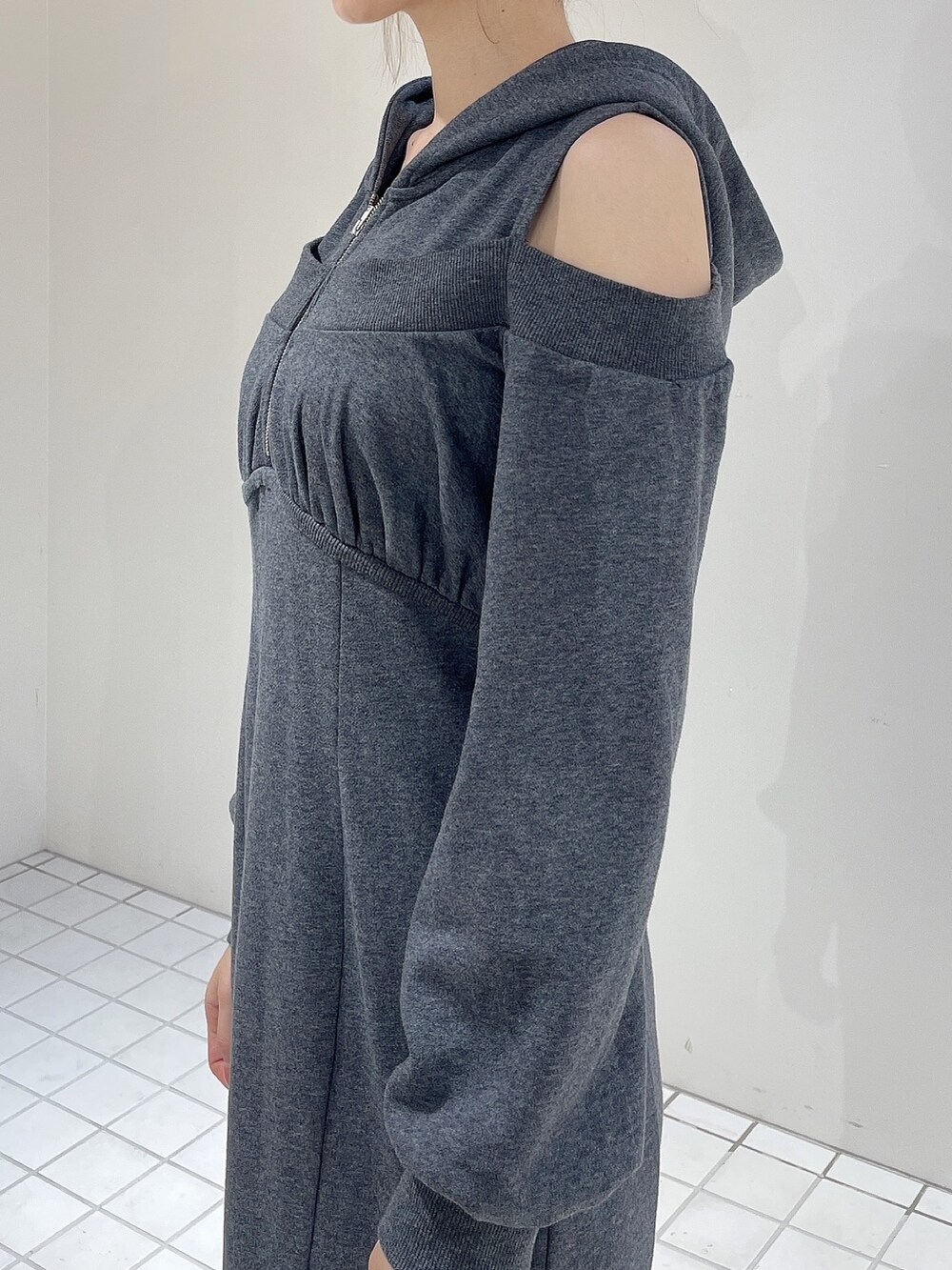 グレー系のワンピース、ブラック系のブーツ、グレー系のシュシュを着用したレディースの秋コーディネートの5枚目の写真