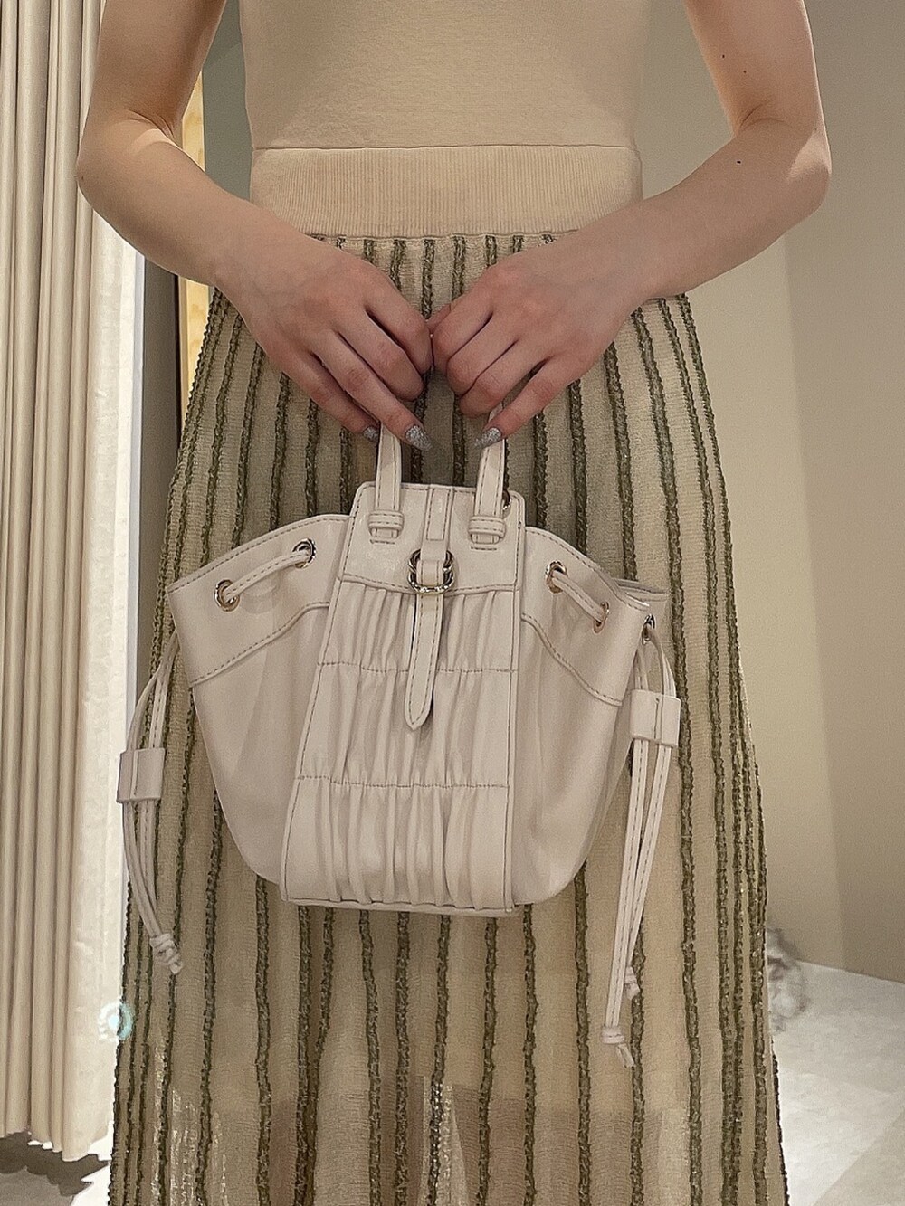 ホワイト系のワンピース、ブラック系のデニムジャケットを着用したレディースの春コーディネートの7枚目の写真