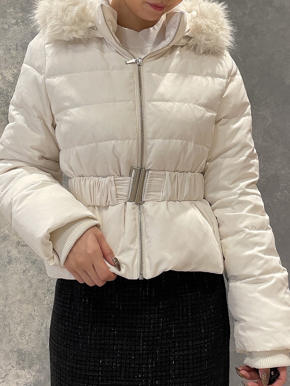 ホワイト系のダウンジャケット/コート、ブラック系のスカート、ブラック系のブーツを着用したレディースの秋コーディネートの5枚目の写真