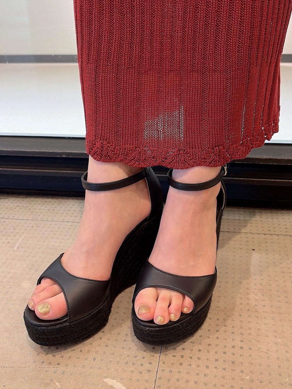 レッド系のワンピース、ブラウン系のハンドバッグ、ブラック系のサンダルを着用したレディースの夏コーディネートの9枚目の写真