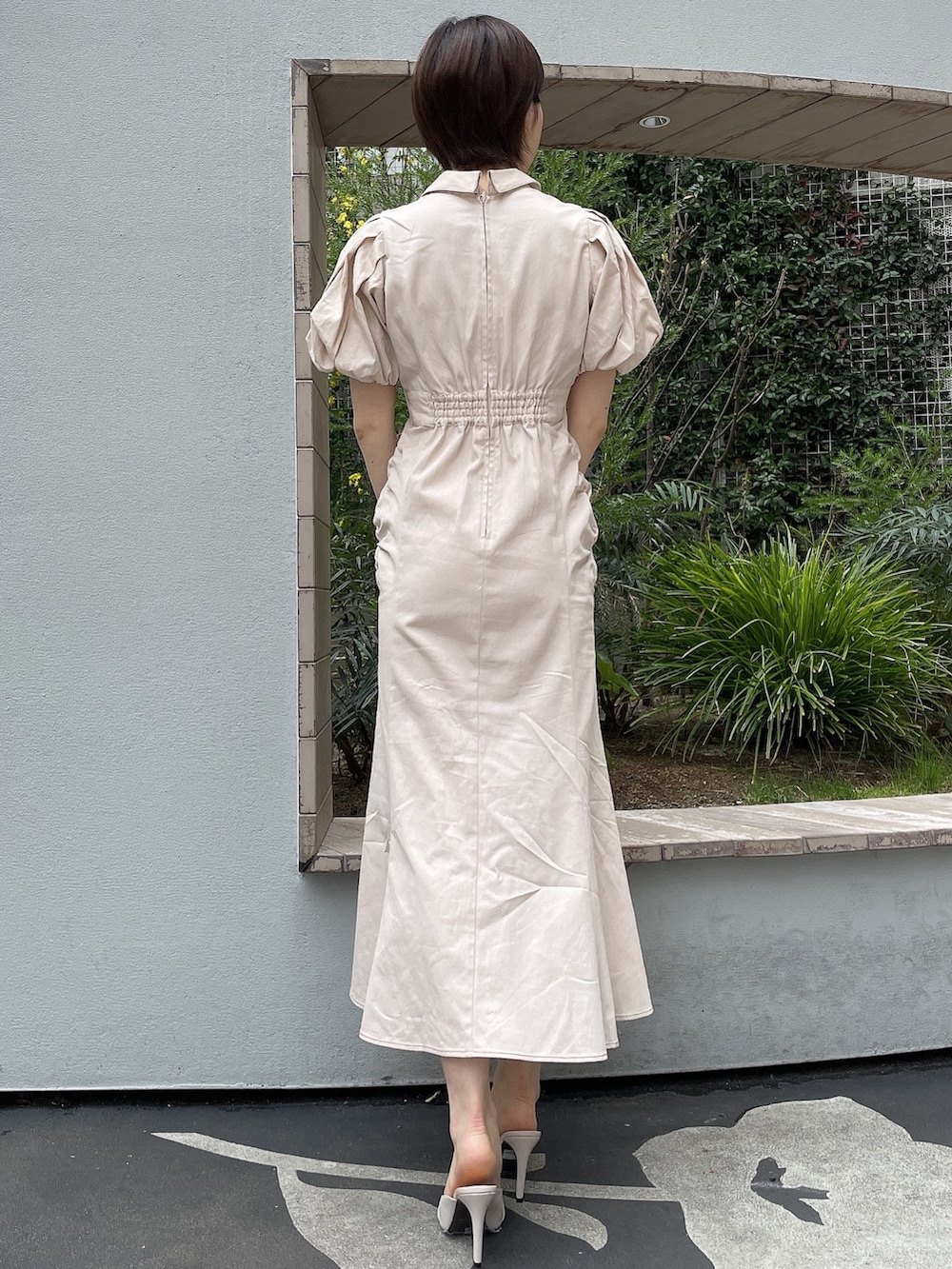 ホワイト系のワンピース、ホワイト系のハンドバッグ、ホワイト系のサンダルを着用したレディースの春コーディネートの3枚目の写真