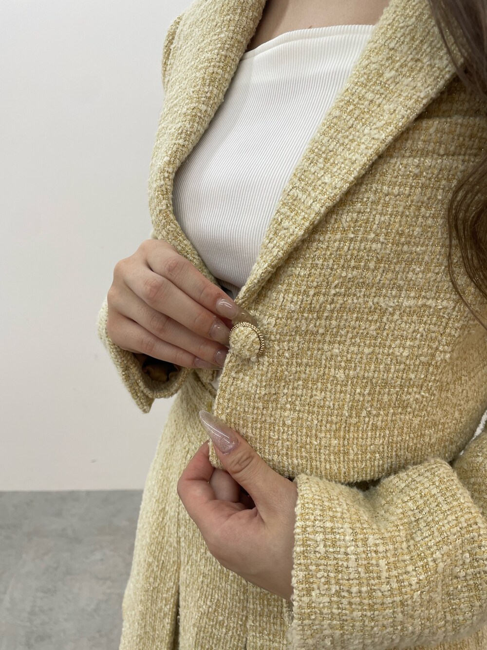 イエロー系のテーラードジャケット、イエロー系のスカート、ホワイト系のTシャツ/カットソーを着用したレディースの秋コーディネートの6枚目の写真