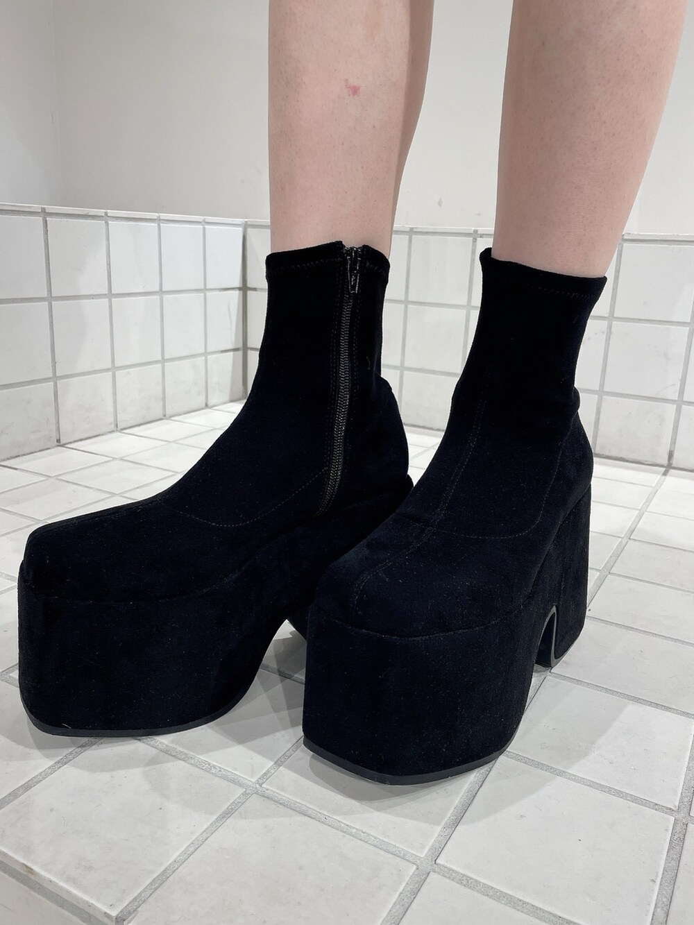 レッド系のテーラードジャケット、レッド系のスカート、ブラック系のニット/セーターを着用したレディースの秋コーディネートの8枚目の写真