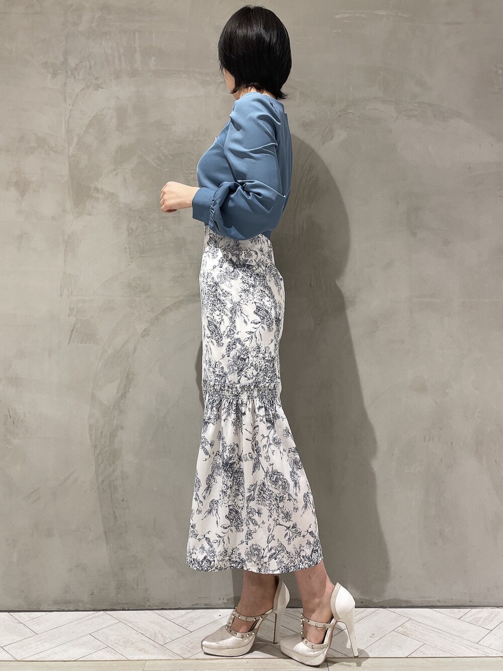 ブルー系のワンピース、ホワイト系のパンプスを着用したレディースの冬コーディネートの2枚目の写真