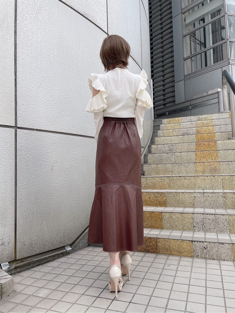 ホワイト系のハンドバッグ、ベージュ系のパンプス、ホワイト系のニット/セーターを着用したレディースの秋コーディネートの5枚目の写真