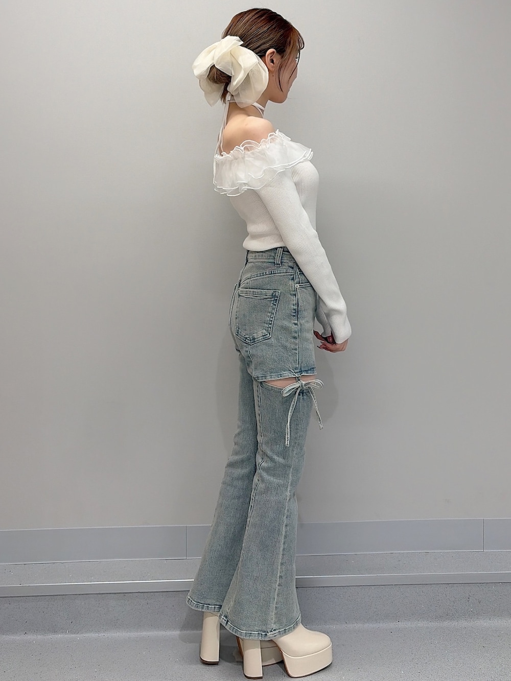 ピンク系のテーラードジャケット、ホワイト系のニット/セーター、ブルー系のデニムパンツを着用したレディースの冬コーディネートの5枚目の写真