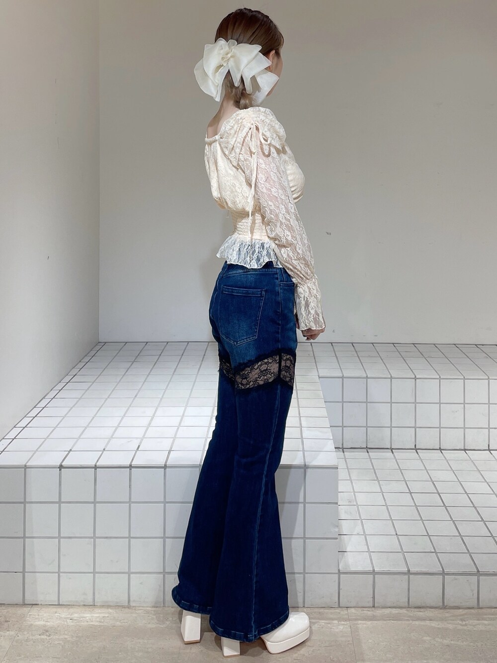 オレンジ系のシャツ/ブラウス、ブルー系のデニムパンツ、ホワイト系のブーツを着用したレディースの春コーディネートの3枚目の写真