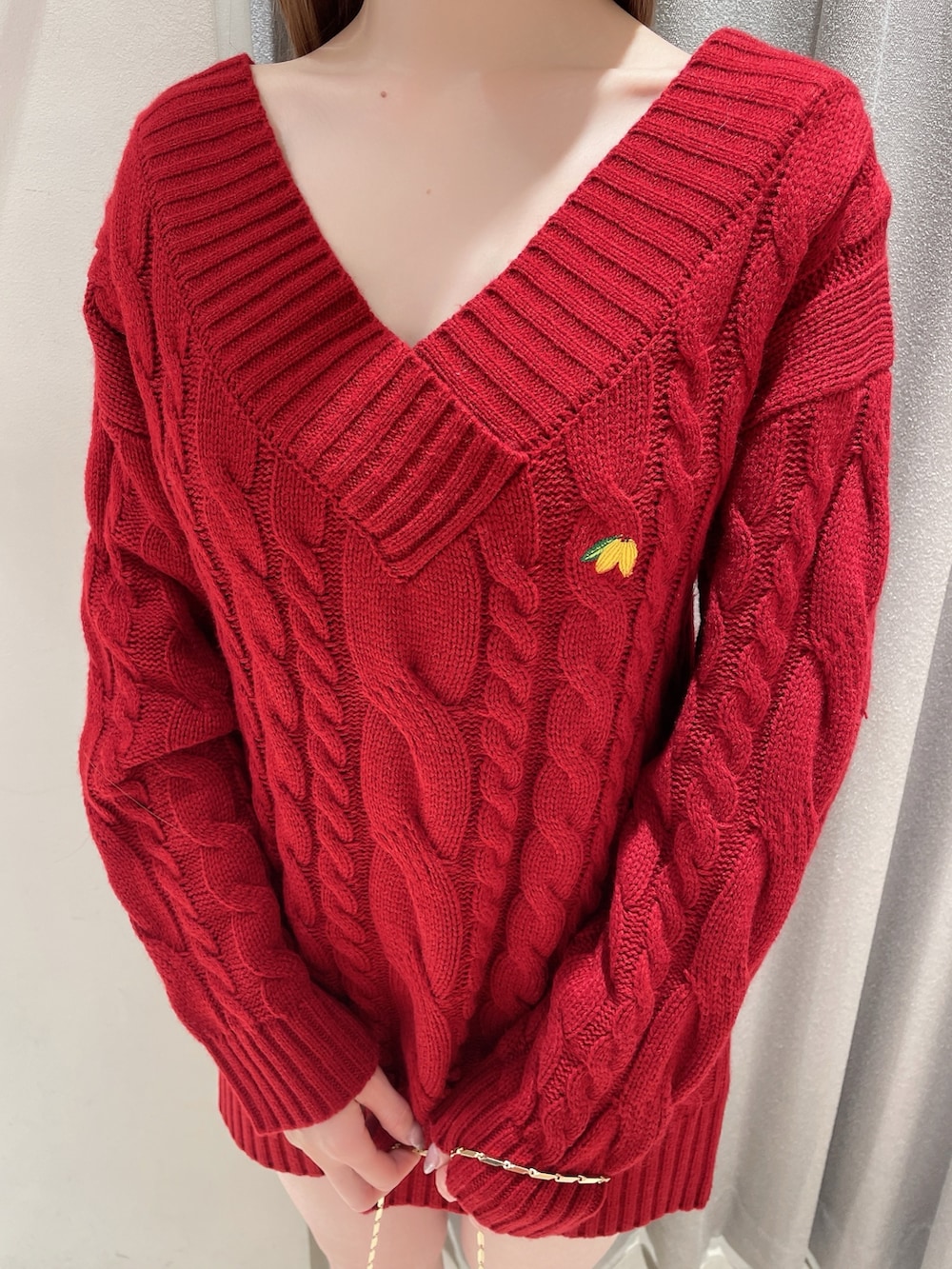 レッド系のニット/セーター、ホワイト系のスカート、ホワイト系のショルダーバッグを着用したレディースの冬コーディネートの6枚目の写真